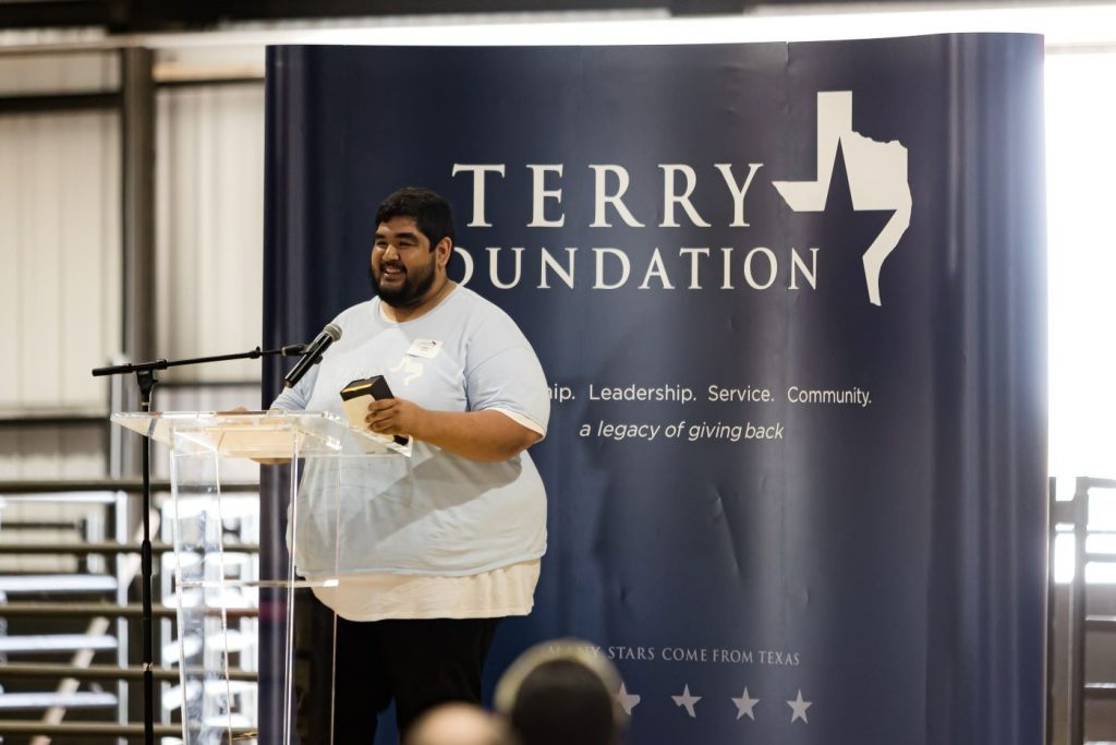 A Terry Scholar gives his senior speech with his Terry gold pen at the 2022 George Ranch Picnic
