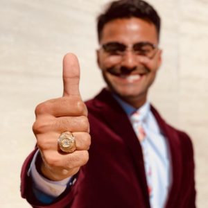 Terry Scholar smiling with thumb up and Aggie ring in focus.